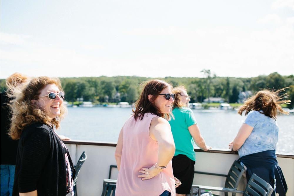 Group of Tourists smile as they pass the large estates on the shoreline of Lake Geneva