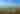 two people stand on a cliffside overlooking a great wooded landscape below