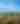 two people stand on a cliffside overlooking a great wooded landscape below