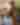 Man outside painting houses on canvas