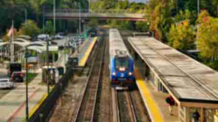 A Metro-North train on railroad tracks pulling into a station in the Hudson Valley.