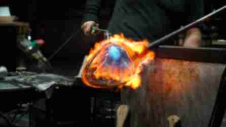 A person using a torch during a hot glasswork demonstration