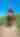 Pristine blue sky, green prairie foreground, man with cowboy hat seen from the back riding horse.