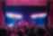 Crowd at a concert at Channel 24, with a band performing on stage under bright pink and white lights as audience members raise their hands and phones.