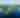 Aerial view of a serene lake with multiple lush, green islands scattered across the deep blue water. A small boat creates a wake, enhancing the peaceful scene.