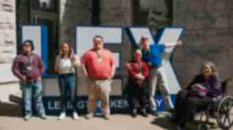 Men and women standing in front of LEX sign at the Lexington Visitors Center
