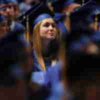 Single girl highlighted in crowd of graduating students.