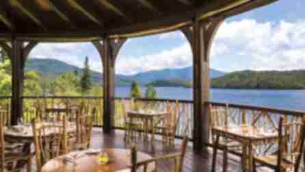 Dining area on porch overlooking lake at Artisans at the Lake Placid Lodge