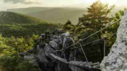 A man walks across a suspension bridge on the new Via Ferrata experience at Mohonk Mountain House
