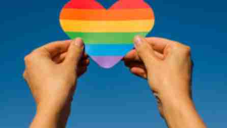 two hands holding a heart made of rainbow colors