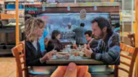 Person holds up picture of When Harry Met Sally in Katz's Deli