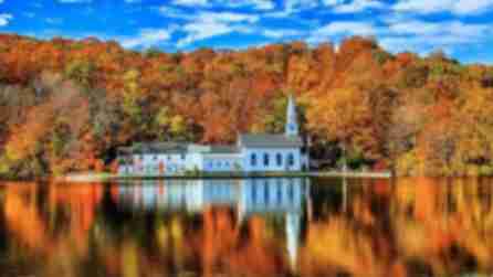 Colorful fall foliage on trees reflecting over a body of water