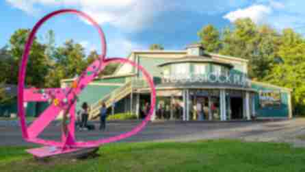 A pink heart sculpture stands on the green lawn of the the Woodstock Playhouse as people line up to attend the Woodstock Film Festival
