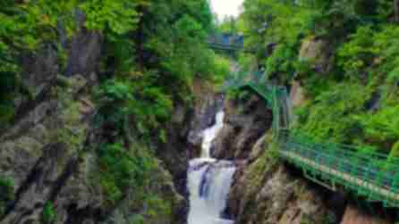 View of water cascading down rocks with a bridge/walking trail alongside it