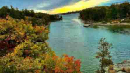 Orange, yellow, and green trees surround the blue St. Lawrence River