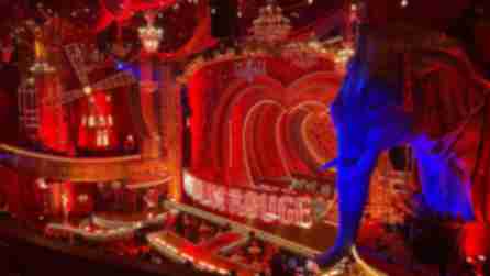 A large elephant prop borders the red-lit stage of Moulin Rouge on Broadway