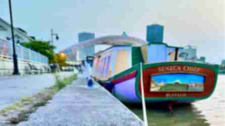 Yellow, green, and brown wood boat docked in Rochester at sunrise
