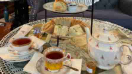 An intricately-designed tea set with a three-tiered stand filled with finger stands