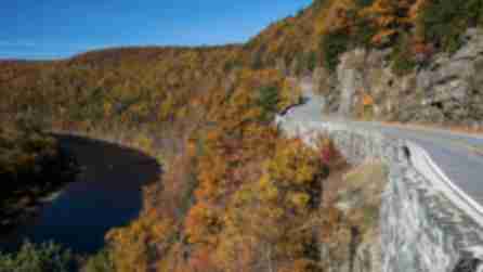 Road winding along the river surrounded by fall foliage