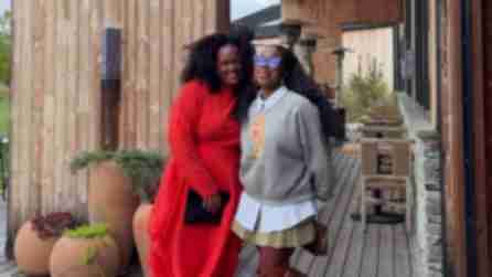 Two Black women smiling for a photo from the outdoor patio at Wildflower Farms in New York State's Hudson Valley.