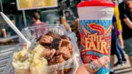 A container of sirloin tips and mashed potatoes next to a plastic up with the Great New York State Fair logo.