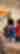 Two people look at a brightly colored painting on the wall. A blurred statue is in the foreground.