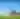 Man runs on a hill by a statue of a cowboy and bison