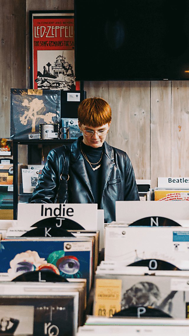 Two people stood looking at records in the record store.