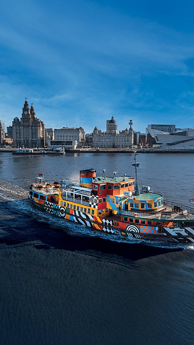 An image of Mersey Ferries boat sailing through the Mersey with the skyline of Liverpool City Centre behind it.