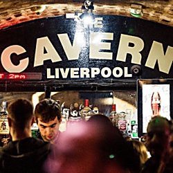 The bar inside the Cavern Club with the words 'The Cavern' painted in white capitals letters on a black archway