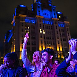 People smiling, at a concert on Liverpool Waterfront