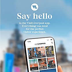 A person holding an iphone with the VisitLiverpool app against the Royal Liver building blurred in the background