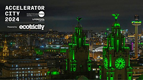 An image of the Royal Liver Building lit up green with a view overlooking the city of Liverpool.