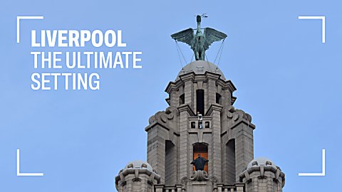 The top of the Royal Liver Building with the Liver Bird at the top. Someone dressed as The Batman is stood on a platform as they are filmed for a movie.