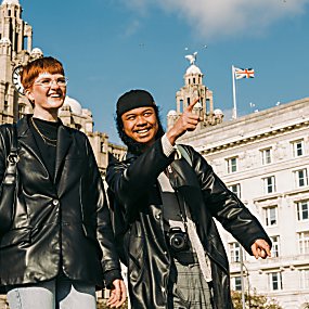 Two people stood in front of the royal liver building.