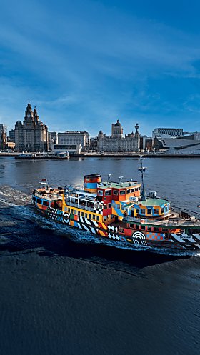 An image of Mersey Ferries boat sailing through the Mersey with the skyline of Liverpool City Centre behind it.