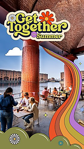An image of people sitting at Royal Albert Docks eating food and enjoying the scenery.