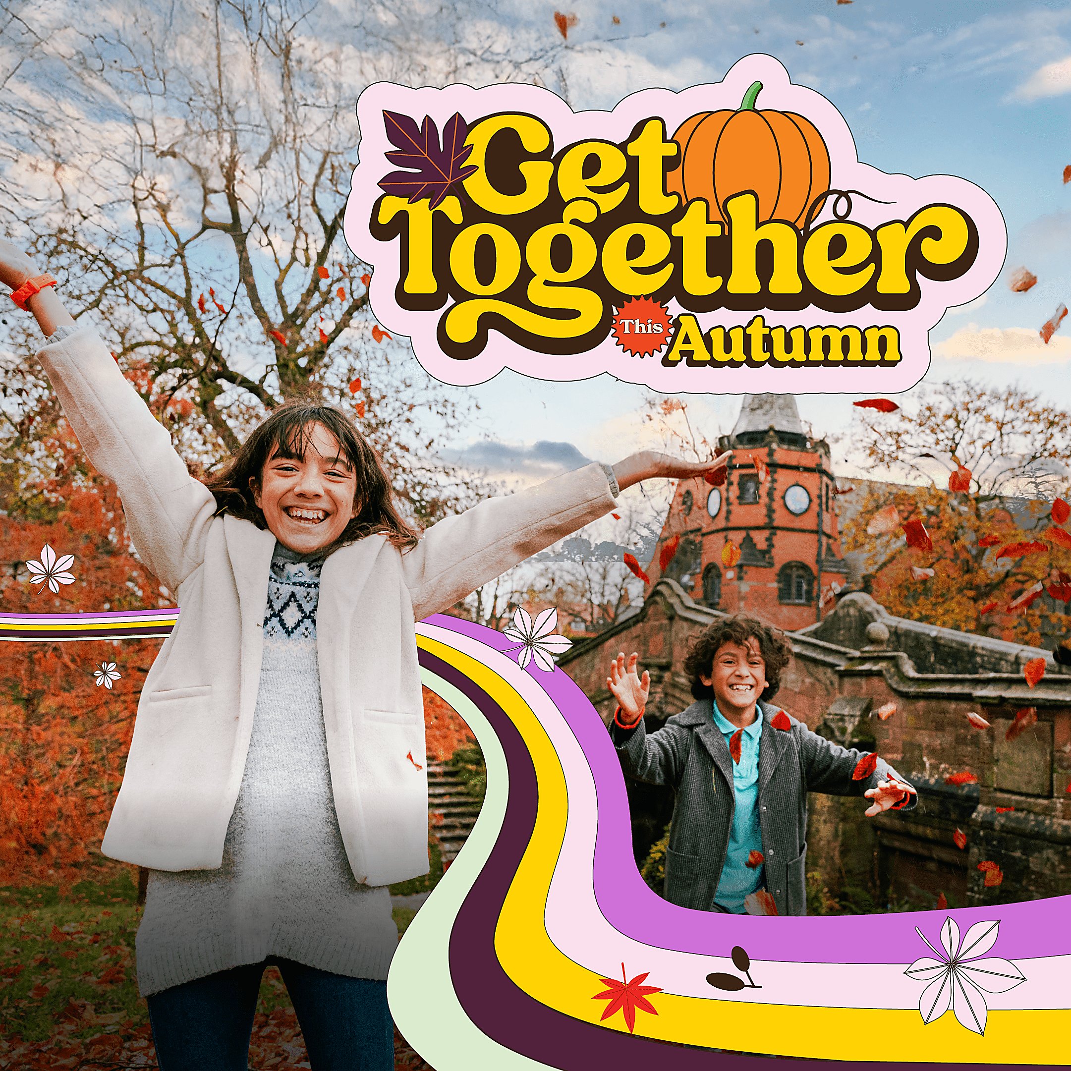 An image of two kids looking at the camera and smiling brightly - the leaves are falling around them with golden trees behind them.