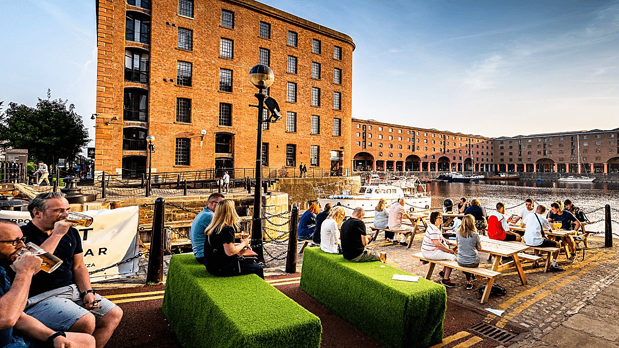People sitting outside at the Royal Albert Dock in summertime
