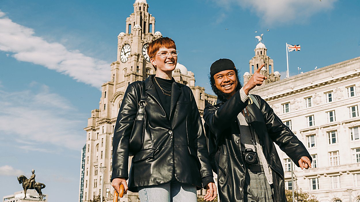 Two people stood in front of the royal liver building.
