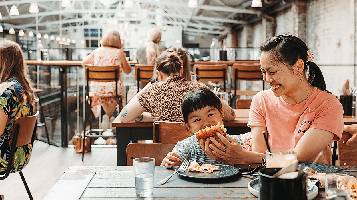 A young child biting into a sandwich