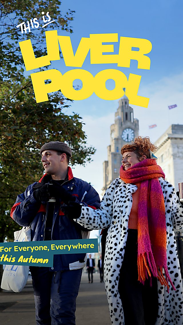 Two people walking through Liverpool city centre in autumn, with the Royal Liver Building in the background and promotional text reading ‘This is Liverpool’.