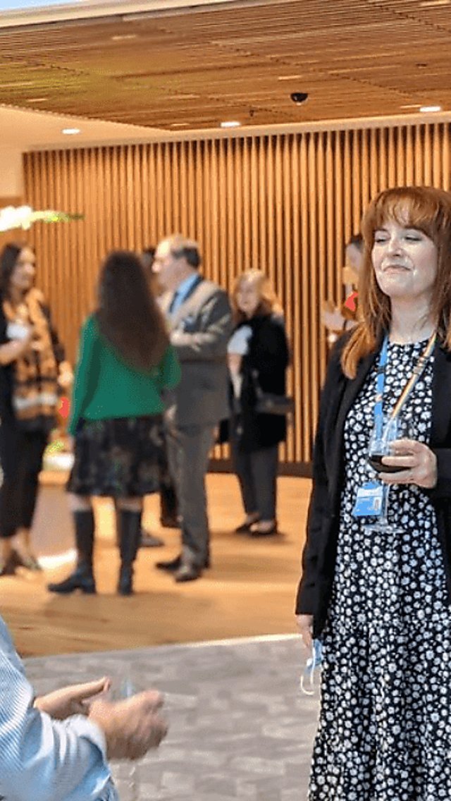 People are networking in a modern event space with plants