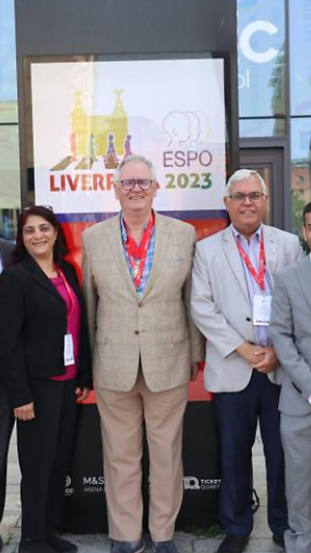A group of people dressed in business wear outside their conference venue