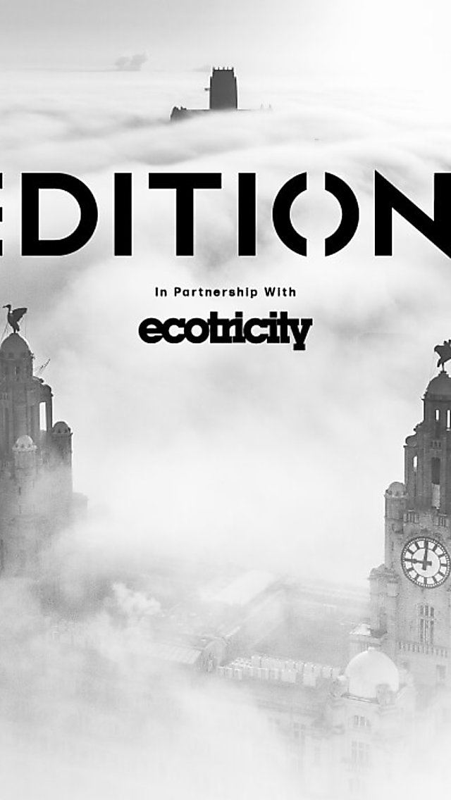The Royal Liver Building clock faces in the clouds and the cathedral in the distance of the clouds