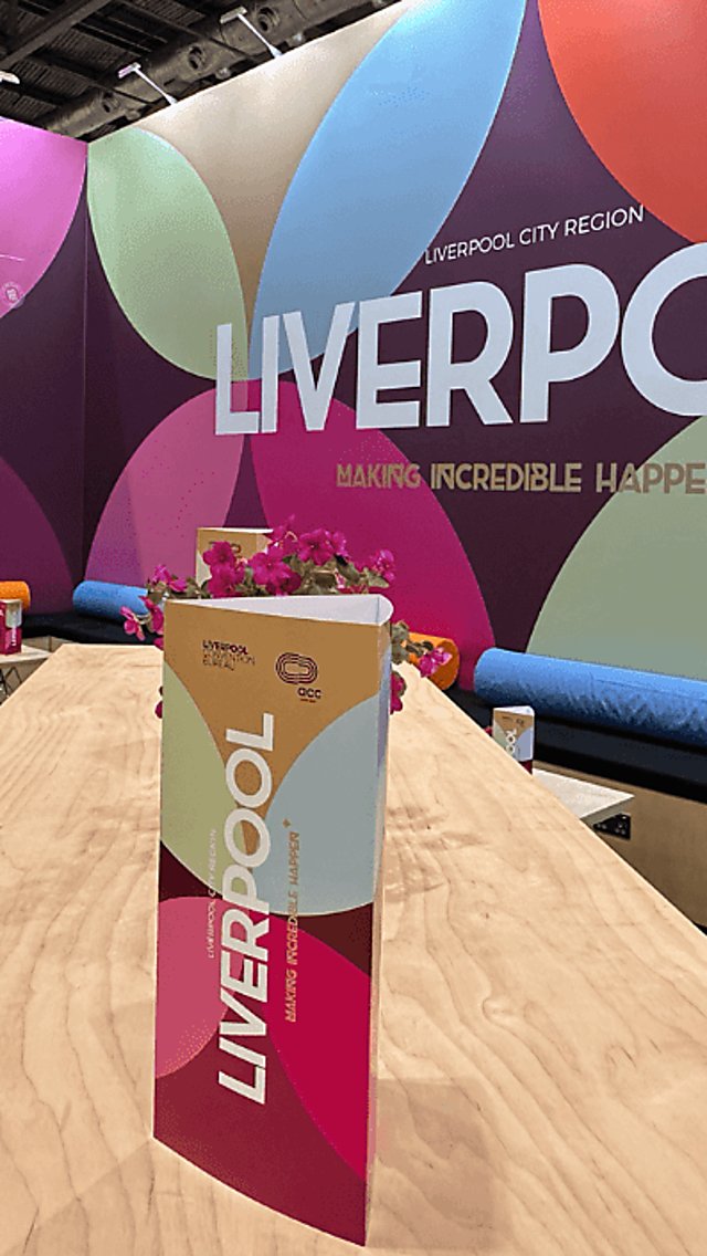 A tradeshow stand with a large Liverpool sign and a tent card.