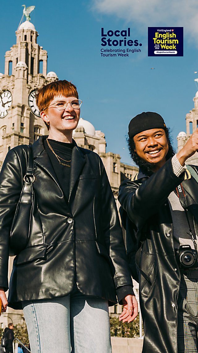 Two people infront of the Royal Liver Building sightseeing.