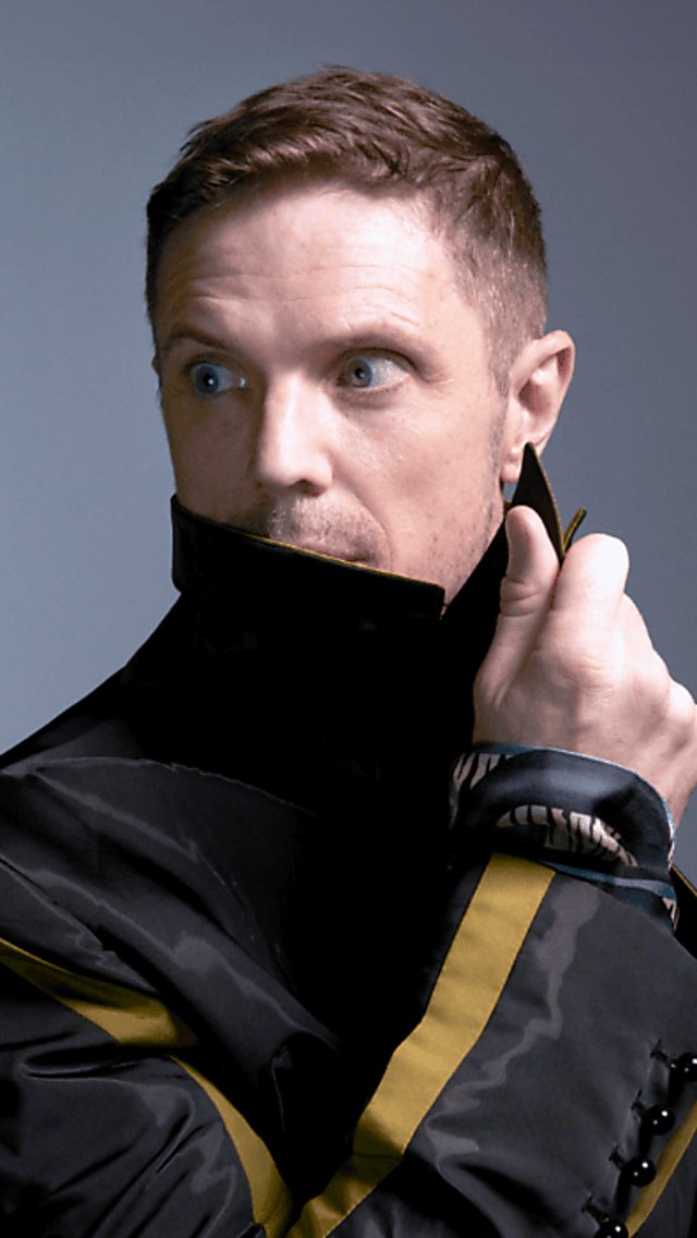 Jake Shears wearing a coat looking away from the camera