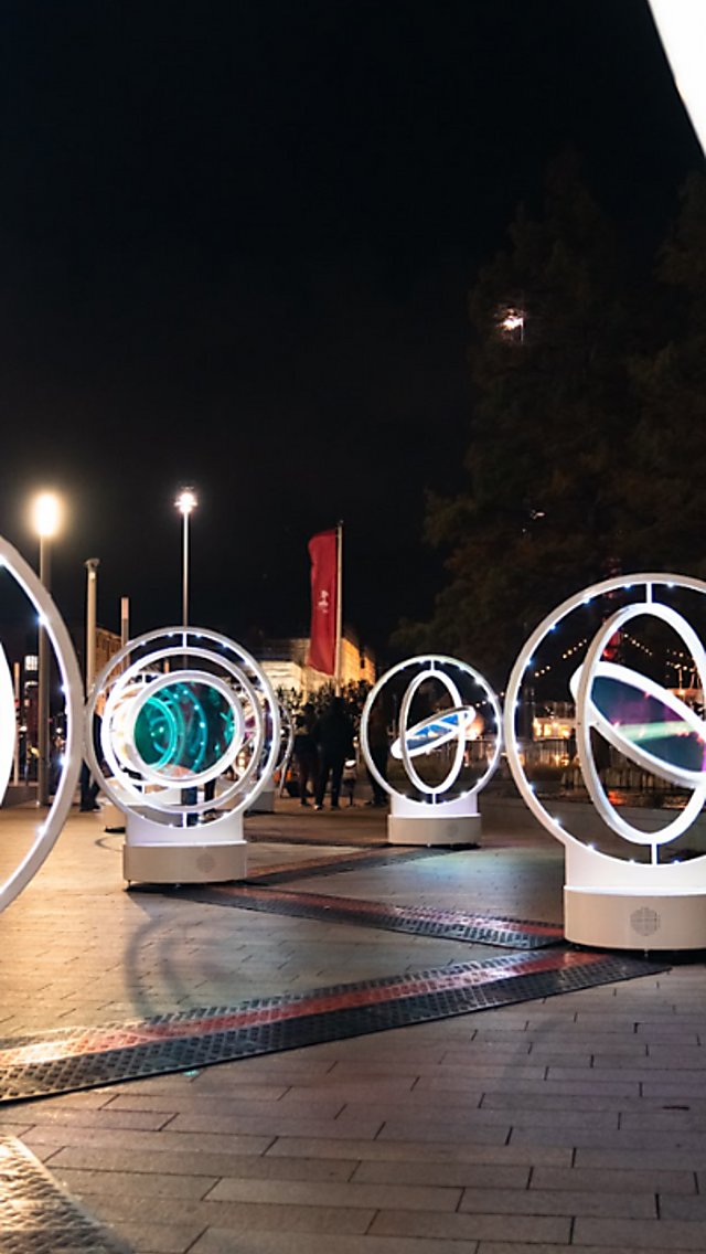 Light installations in circles that spin around with lights in the middle of it.