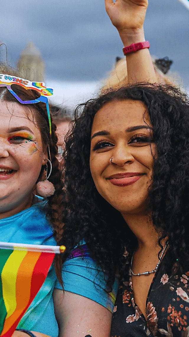 Two girls with pride flags on Liverpool Pier Head